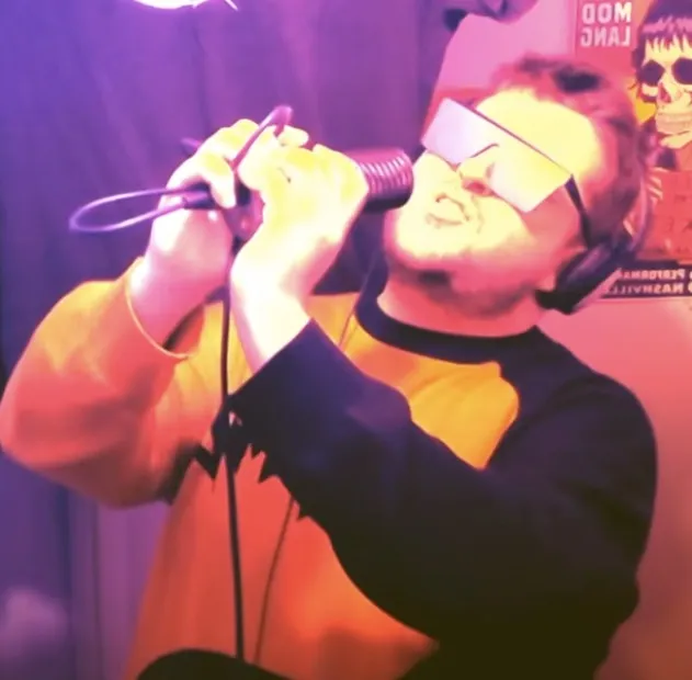 Brian singing into a microphone