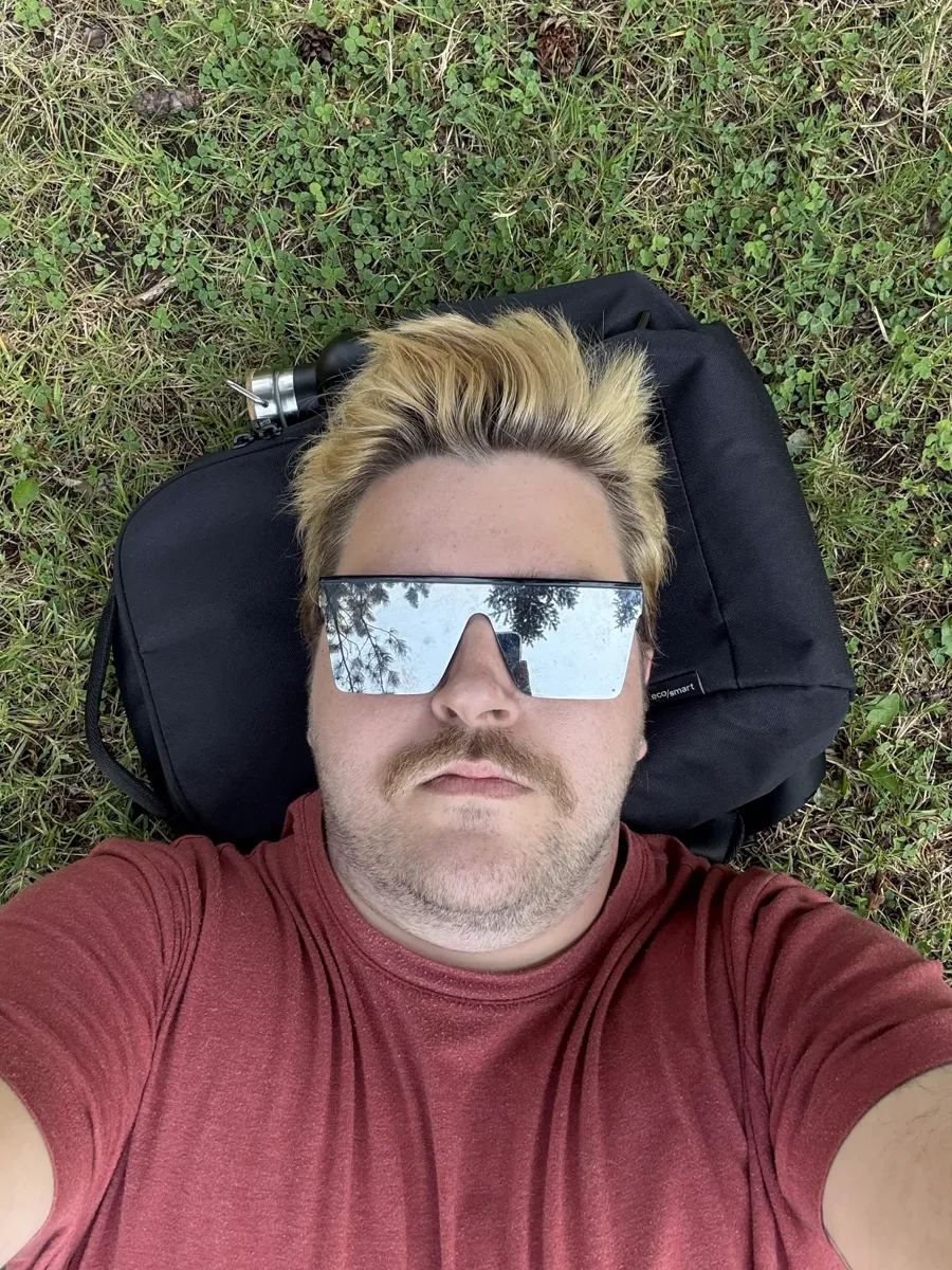 Brian lying in the grass wearing mirrored sunglasses